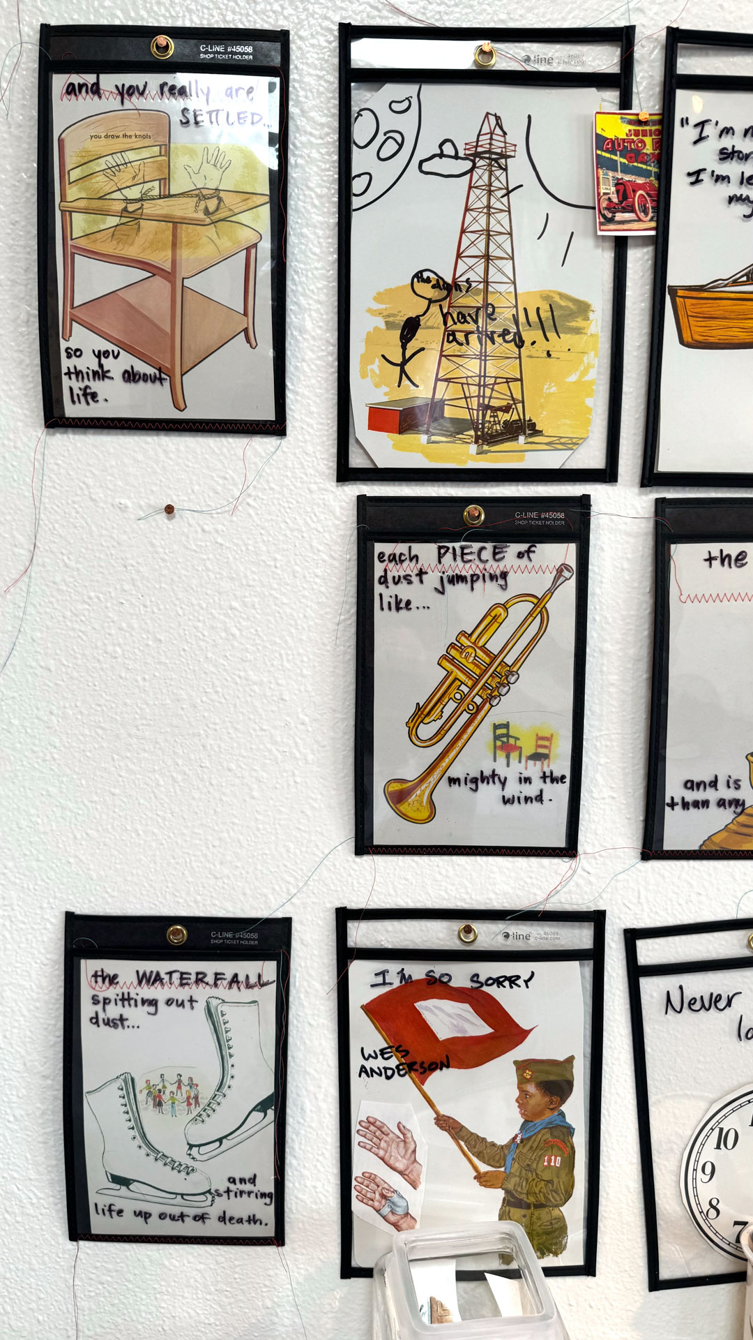 installation with wood table cut in half against wall, job folder, collage materials, audience participation
